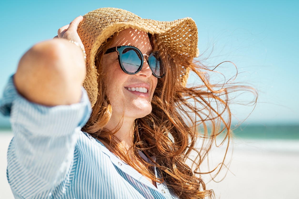 woman hat summer beach sunglasses hair in the wind