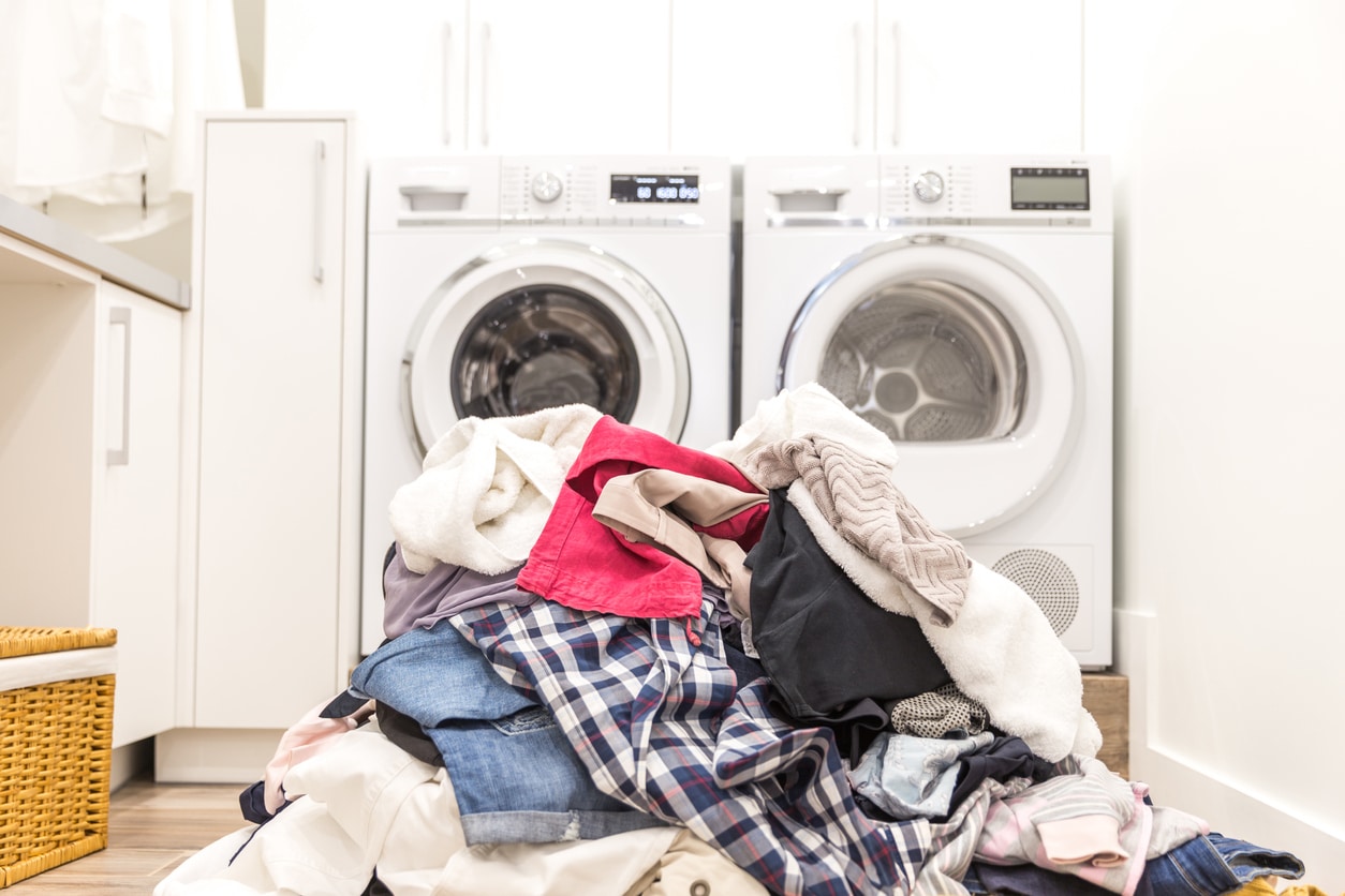 laundry room pile of dirty laundry in front of the washing machine and dryer